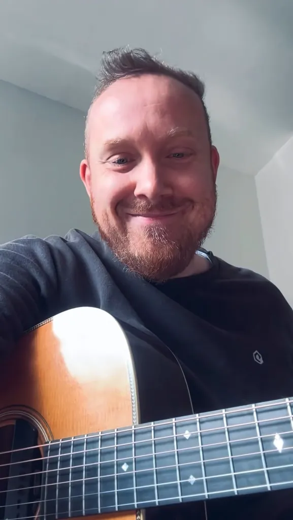Joël thuis met akoestische gitaar